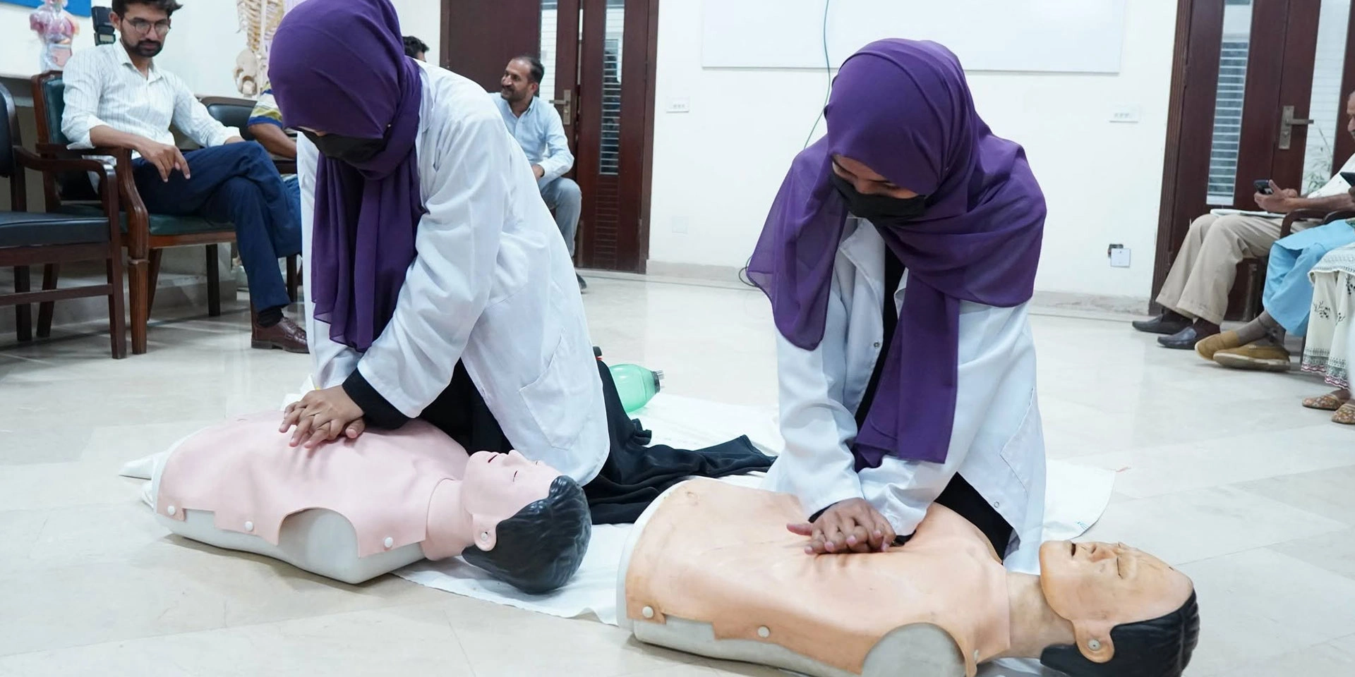 Medical volunteers practising CPR on training mannequins at a Muslim Medical Mission life support workshop